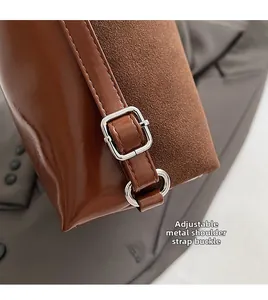 Close-up of silver hardware buckle and adjustable strap on a brown tote bag