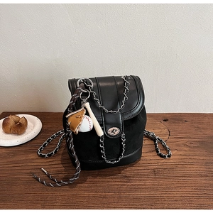 Detail of black frosted shoulder bag with metal lock and cute baseball charm accessories
