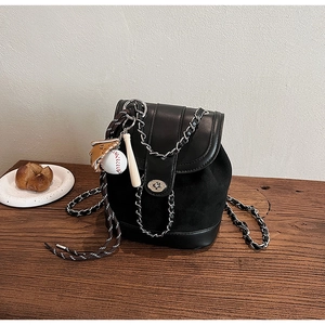 Detail of frosted black mini backpack featuring silver chain and baseball glove charm