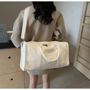 Gran bolsa de viaje crema con correa ajustable mostrada en un entorno de estilo de vida