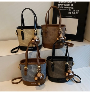Four colorful bucket bags with plush monkey charms and adjustable shoulder straps