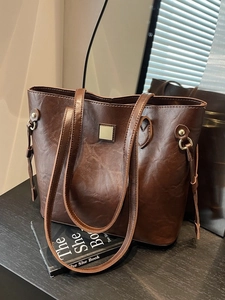 Minimalistische braune Leder-Einkaufstasche mit Goldplatte und Plissee-Struktur