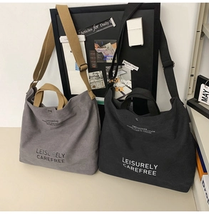 Detail view of large canvas tote bags with adjustable straps and leisure lettering