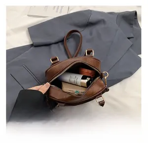 Internal storage view of brown PU leather bag with phone and cosmetics inside