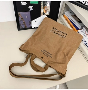 Brown canvas tote bag with adjustable shoulder strap and stylish leisure print text