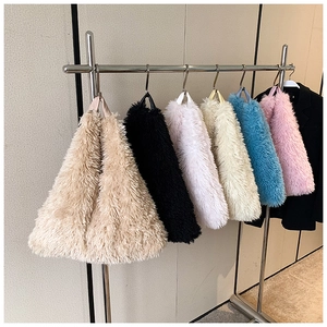 Variety of plush tote bags in different colors hanging on sleek metal hangers