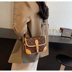 Makroaufnahme der Retro-Monogramm-Tasche mit verstellbarem Riemen und Schnallendetail