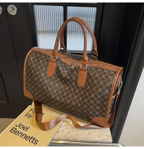 Detailansicht der karamellfarbenen Reisetasche mit geometrischem Muster und Silberteilen