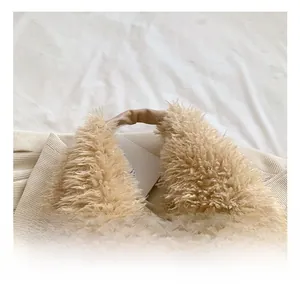 Close-up of soft plush tote bag with brown faux leather handle and fluffy beige faux fur