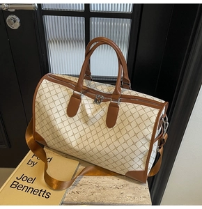Detail der großen Reisetasche mit braunem Rautenmuster und hochwertigem Lederbesatz