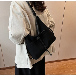 Detailed view of the large black hobo shoulder bag with drawstring side on a model