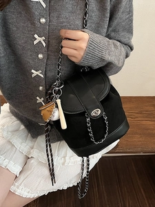 Fashion matte black mini backpack with silver chain strap and baseball charms on model