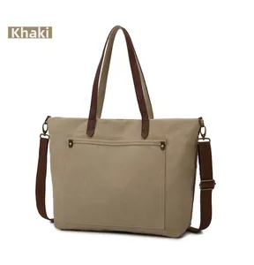 Detalle del bolso tote de lona caqui con correas marrones y herrajes de bronce retro