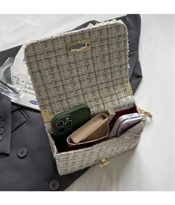 Close-up of the red lining interior of this tweed bag holding phone and cosmetics