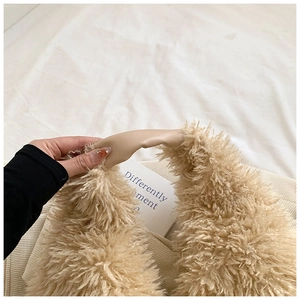 Detail of plush faux fur tote bag with matching leather handle and soft texture