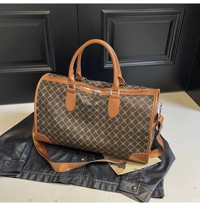 Detailansicht der Reisetasche mit braunem Karomuster auf einer Lederjacke