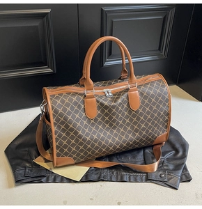 Detail der Reisetasche mit geometrischem Muster, braunen Ledergriffen und Metallteilen