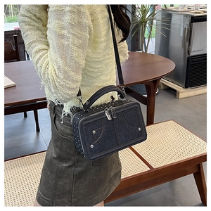Detail der blauen Denim-Handtasche mit silbernen Nieten und edlen Metallbeschlägen