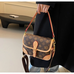 Details der Vintage-Umhängetasche mit breitem Stoffgurt und klassischem Muster