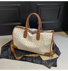 Detail der großen Reisetasche mit braunem Karomuster und Ledergriffen für Damen und Herren