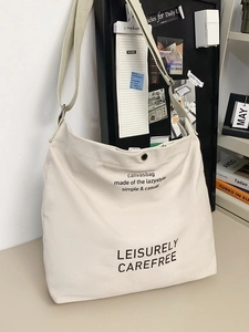 Large capacity off-white canvas crossbody bag for students featuring minimalist lettering