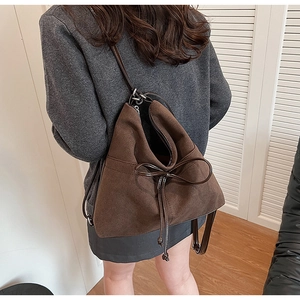 Rear view of model wearing a vintage brown matte leather tote bag with bow detail