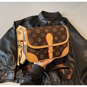 Detailansicht der Vintage-Umhängetasche mit braunem Monogramm und breitem Stoffriemen