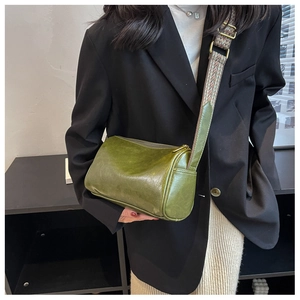 Detail of vintage green cylinder bag featuring a colorful geometric patterned wide strap