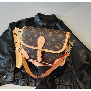 Detailansicht der Vintage-Tasche mit Monogramm-Muster und rotem Leder-Schultergurt