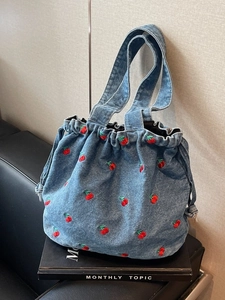 Blue denim bucket bag with red cherry embroidery and drawstring closure for women