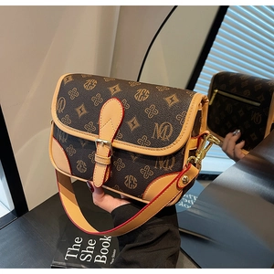 Detail der Vintage-Umhängetasche mit Monogramm, Goldbeschlägen und roten Farbkanten