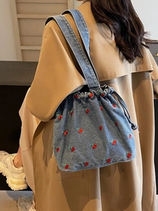 Blue denim bucket bag with red cherry embroidery and drawstring closure for women