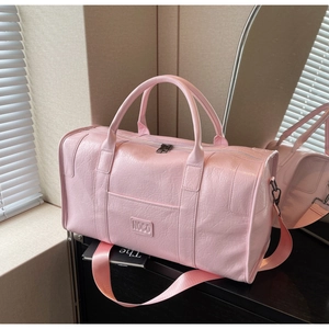 Detalle de la textura de cuero PU rosa y logo NOCO en un bolso de viaje deportivo
