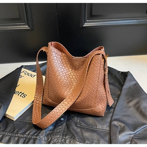 Détail d'un sac à bandoulière en cuir tressé marron vintage avec garniture dorée chic