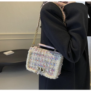 Detail of colorful tweed crossbody bag with pearl trim and golden chain strap