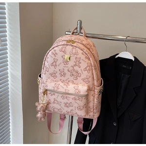 Detailansicht eines rosa Lederrucksacks mit Bärenprints und passendem Bärenanhänger