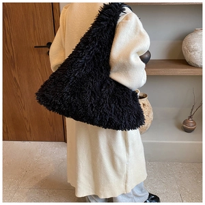 Detail of a large black faux fur tote bag showing the plush texture and spacious design