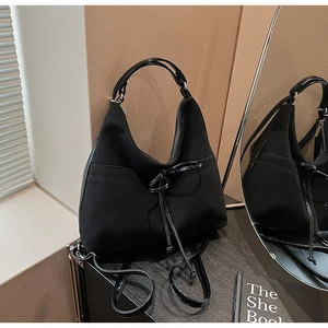 Detail shot of black hobo bag showing bow tie knot and smooth zipper closure