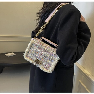 Close-up of multicolored tweed crossbody bag with white pearl trim and gold chain strap