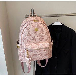Detailansicht des rosa Rucksacks mit Bärenmuster, goldenem Reißverschluss und Bärenanhänger