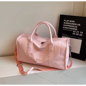 Detalle de bolsa de viaje de cuero PU rosa con logo NOGO grabado y asas resistentes