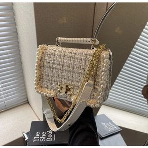 Detail of tweed crossbody bag featuring pearl trim and elegant gold twist lock