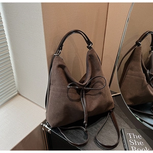 Macro shot of retro dark brown matte hobo bag featuring a thin decorative bow detail