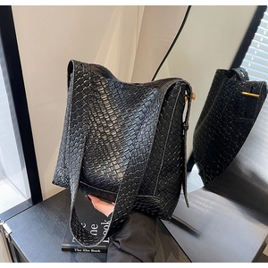 Vue détaillée de la texture tressée noire d'un grand sac seau à bandoulière