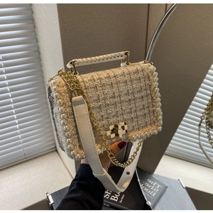 Detail of tweed crossbody bag with pearl trim and golden lock on white leather