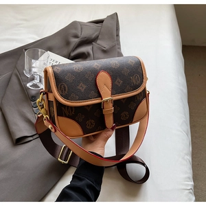 Details der Vintage-Umhängetasche mit Buchstabenmuster und stilvollem breitem Gurt
