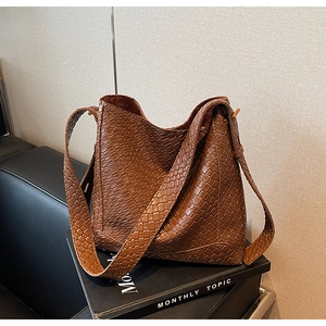 Vue macro d'un sac seau marron en cuir tressé au design vintage avec détails texturés