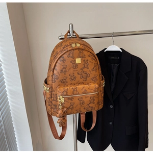 Detailansicht brauner Rucksack mit Bärendruck, Goldnieten und Bärenanhänger