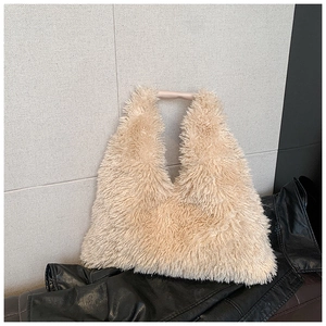 Close-up of the plush faux fur texture and smooth leather handle of the beige tote bag