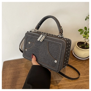 Detail der dunkelgrauen Denim-Struktur kleinen quadratischen Tasche mit silbernen Nieten